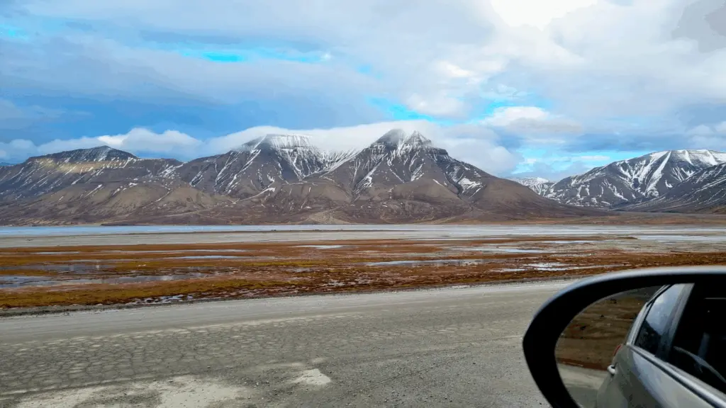 Sur l'image : la vue sur les montagnes du Svalbard prise depuis la fenêtre de la voiture sur le chemin du client.