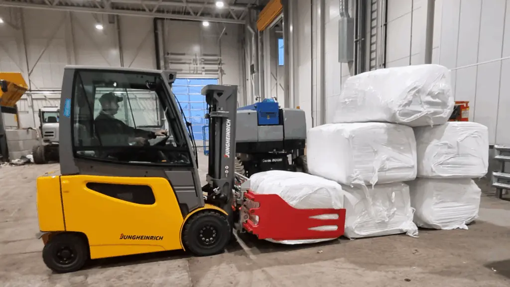 Sur l'image : un camion charge des balles carrées dans l'installation de recyclage de Svalbard.
