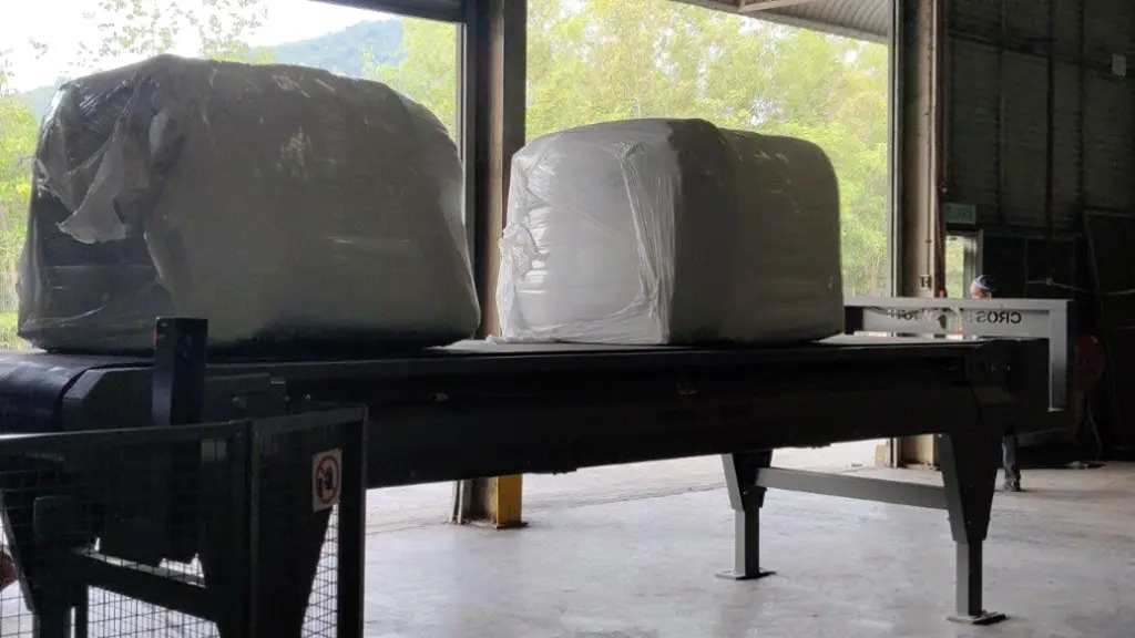 On Image: Wrapped bales stand on conveyor. Wrapping pulp bales creates dense bales that are easy to handle and transport